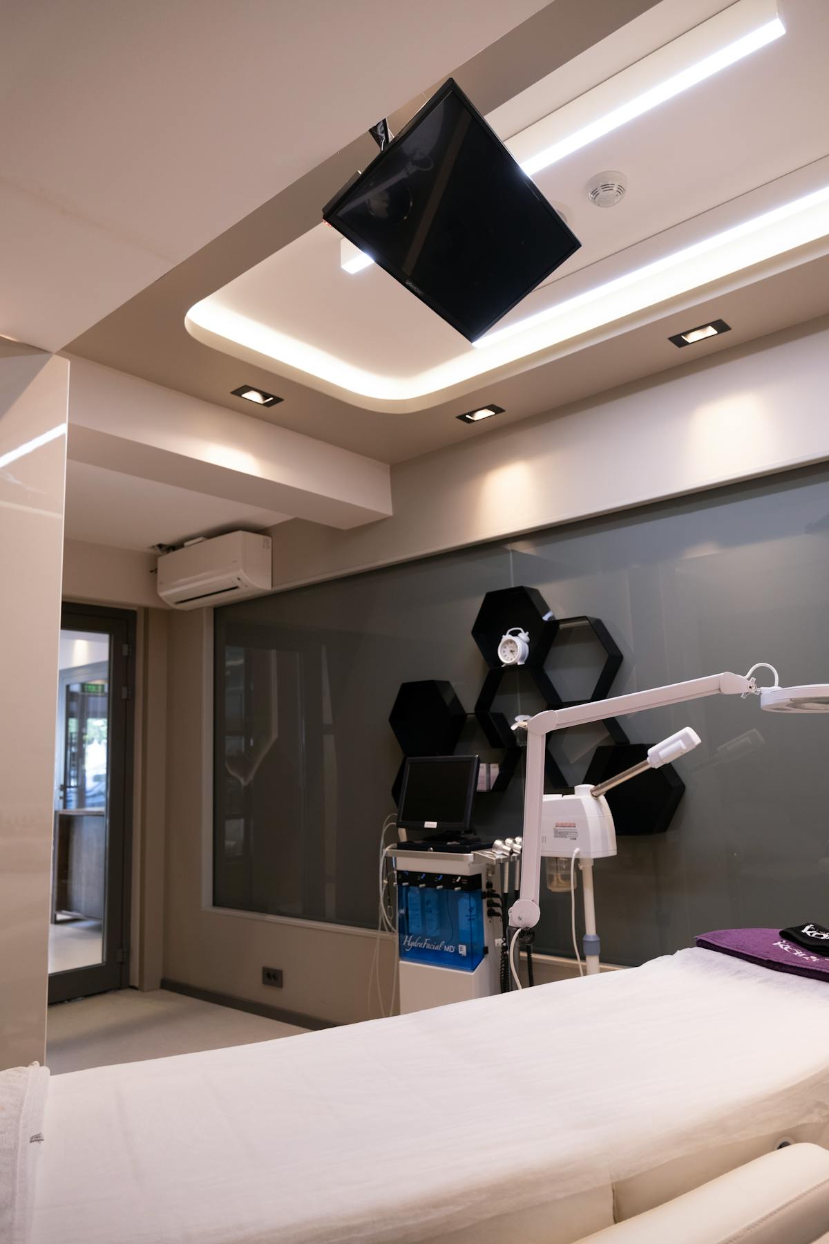 Modern premium wellness treatment room with treatment bed and clinical equipment
